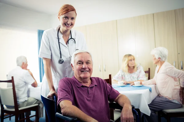 Verpleegkundige met senior man in rolstoel — Stockfoto