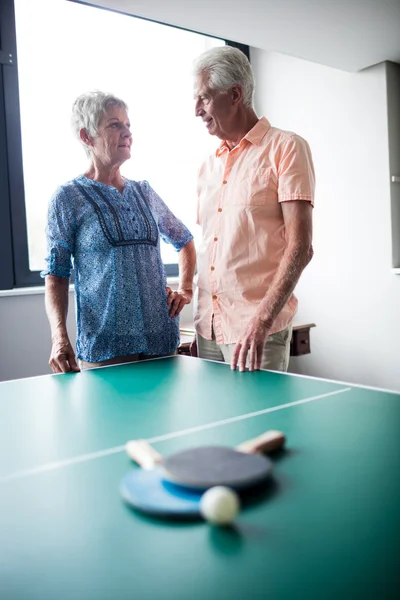 Senioren interagieren hinter Tischtennistisch — Stockfoto