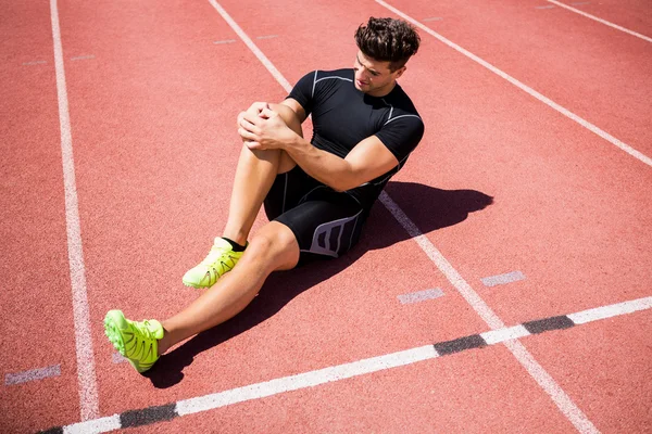 Atleta aquecendo na pista de corrida — Fotografia de Stock