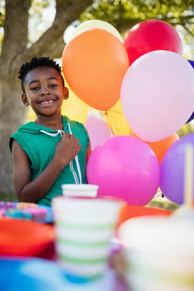 Мальчик рядом с воздушными шарами — стоковое фото