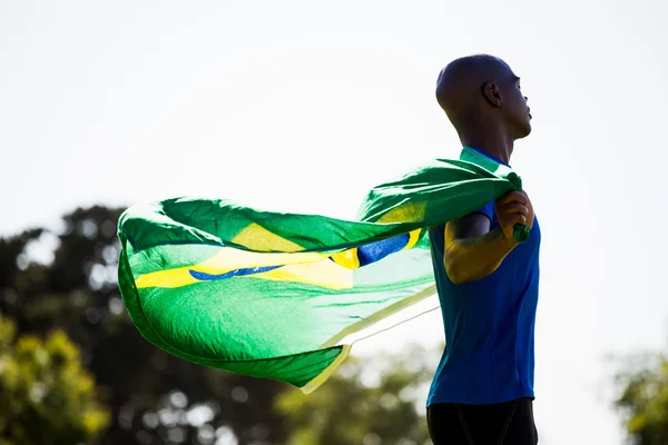 Sportovec pózuje s brazilská vlajka — Stock fotografie