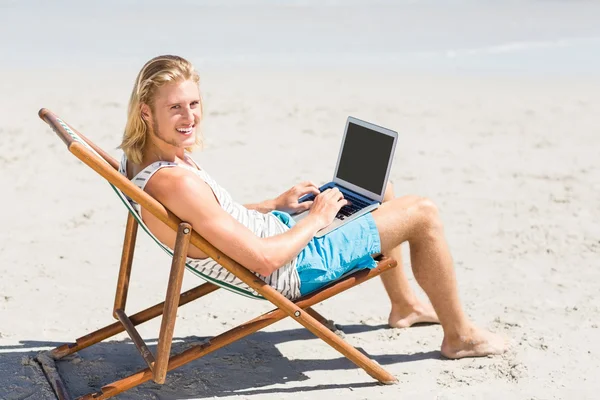 Homem sentado em poltrona na praia — Fotografia de Stock