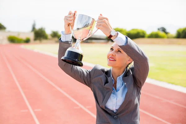 Business woman holding up trophy — стоковое фото