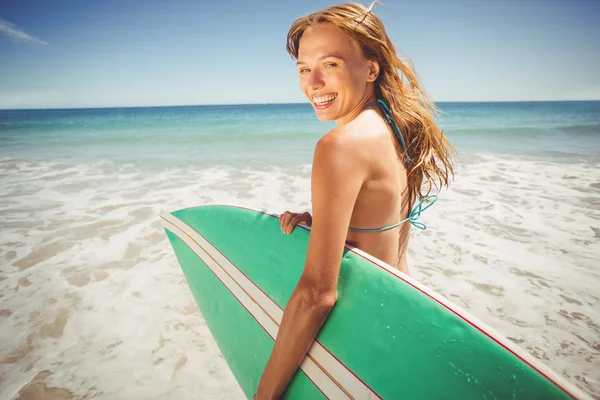 Vrouw bedrijf surfplank op strand — Stockfoto