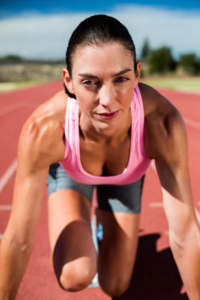 Kadın atlet hazır pozisyonu çalıştırmak için — Stok fotoğraf