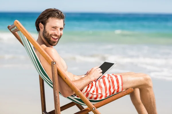 Muž sedící na křesle na pláži — Stock fotografie