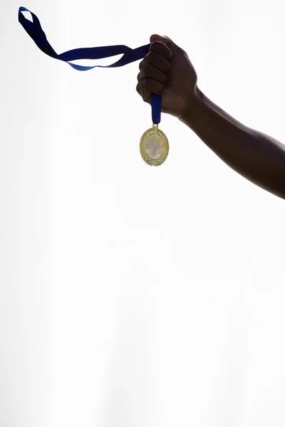 Hand of athlete holding gold medal — Stock Photo, Image