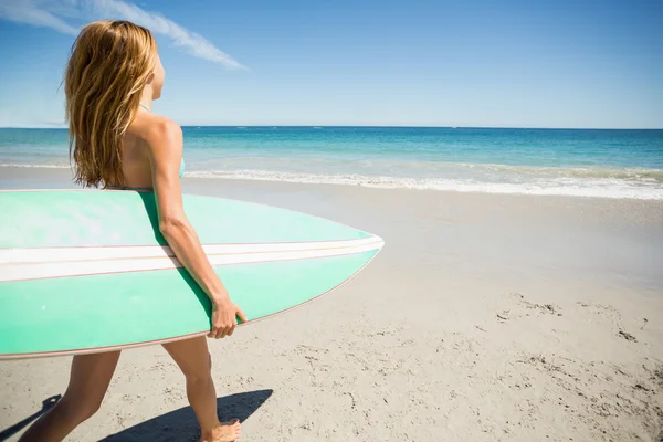 Donna che cammina con tavola da surf sulla spiaggia — Foto Stock