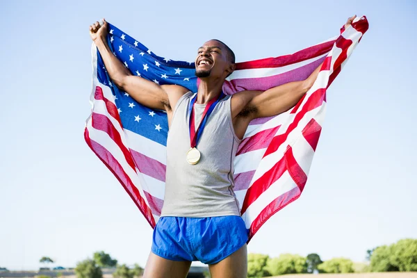 Idrottsman med amerikanska flaggan och medaljer — Stockfoto