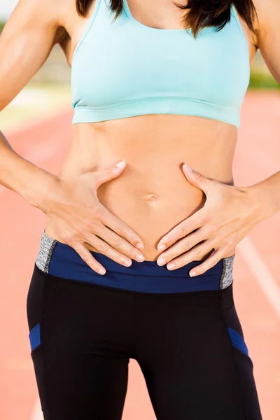 Female athlete touching her belly — Stock Photo, Image