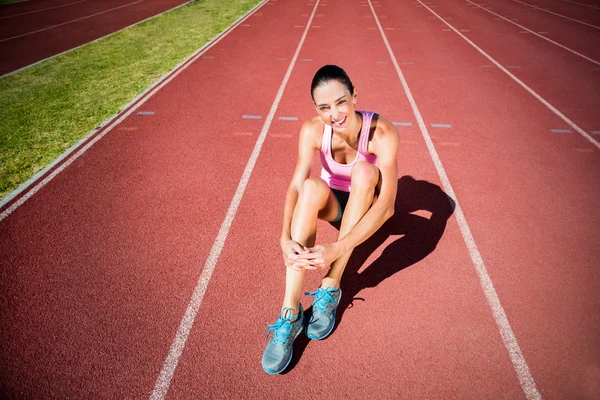 Atleta donna seduta sulla pista da corsa — Foto Stock