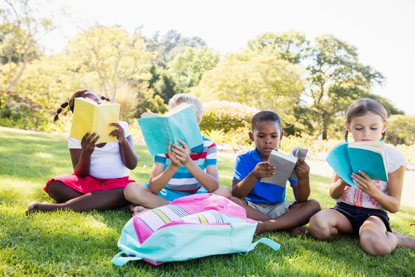 Kids reading books during sunny day Stock Photo