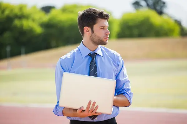 Empresário usando laptop na pista de corrida — Fotografia de Stock