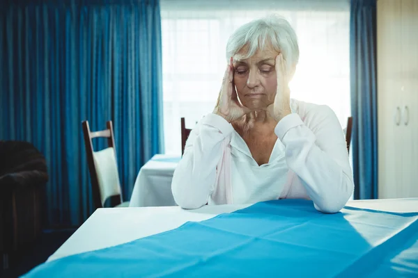 Pensionär med huvudvärk i pension house — Stockfoto