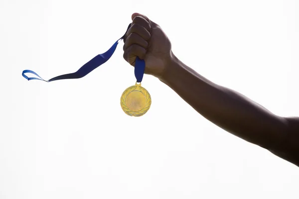 Hand of athlete holding gold medal — Stock Photo, Image