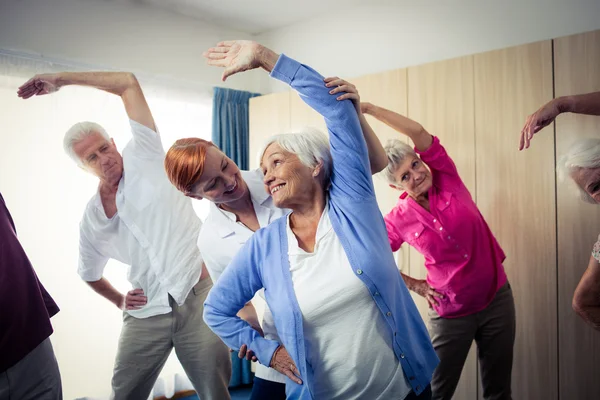 Personas mayores haciendo ejercicios con la enfermera — Foto de Stock