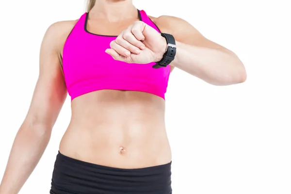 Женщина-атлет смотрит на свои умные часы — стоковое фото