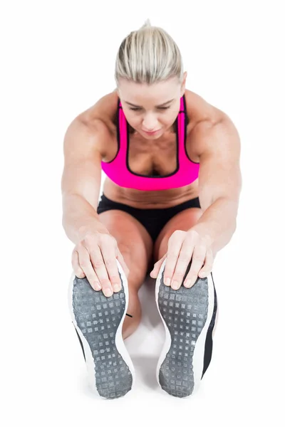 Vrouwelijke atleet zitten en stretching — Stockfoto