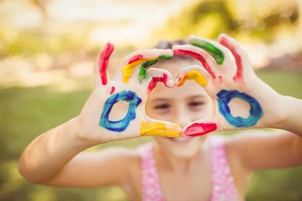 Menina fazendo um coração com seus braços pintados — Fotografia de Stock