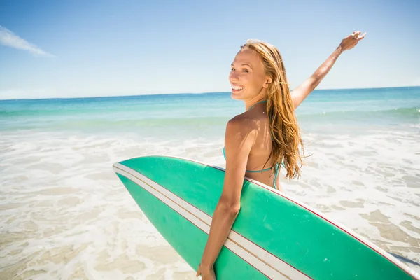 Donna in posa con tavola da surf sulla spiaggia — Foto Stock