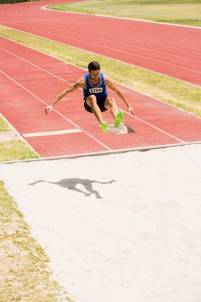 Спортсмен, виконуючи довгий стрибок — стокове фото