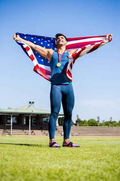 Idrottsman med amerikanska flaggan och medaljer — Stockfoto