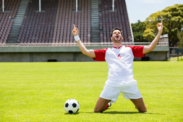 Excited football player kneeling — Stock Photo, Image