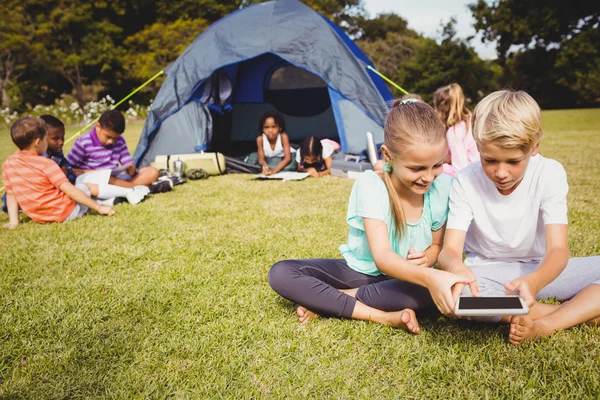 Leende barn söker deras tablet — Stockfoto