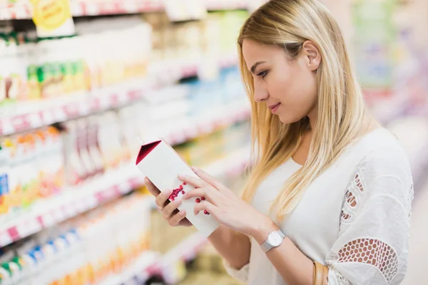 Klant kijkt op fles vruchtensap — Stockfoto