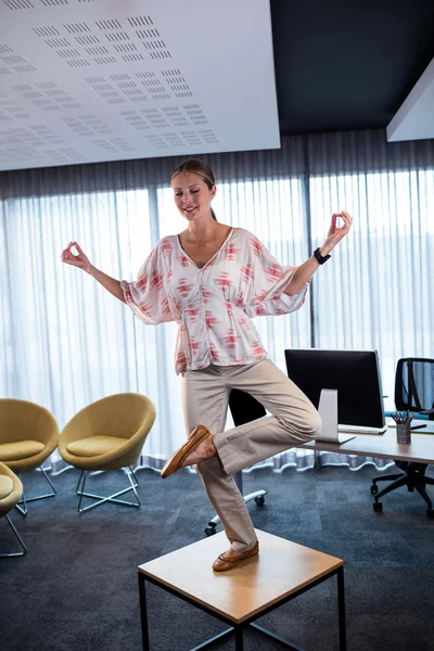 Femme d'affaires faisant du yoga sur une table — Photo