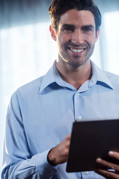 Leende affärsman med hjälp av en tablett — Stockfoto