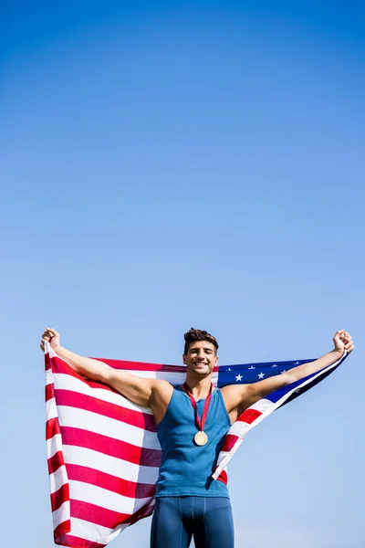 Idrottsman med amerikanska flaggan och medaljer — Stockfoto