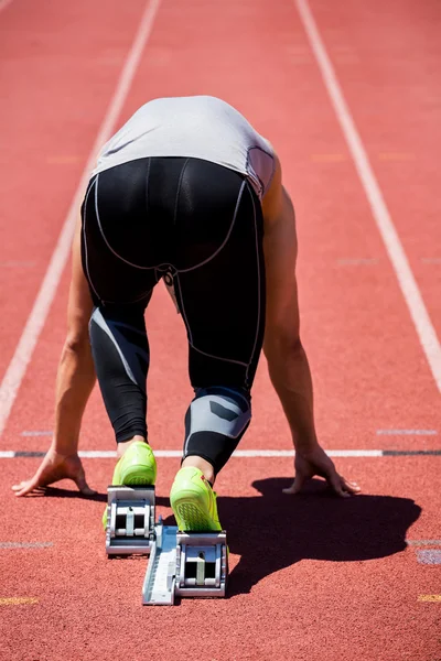 Athlete on starting block about to run — Stock Photo, Image