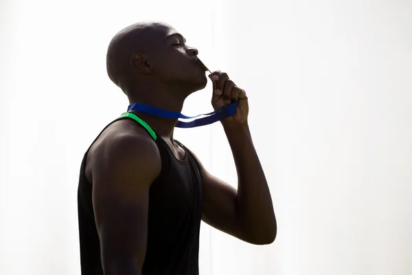 Atleta beijando sua medalha de ouro — Fotografia de Stock