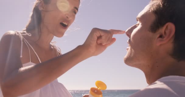 Femme mettant de la crème solaire à son petit ami — Video