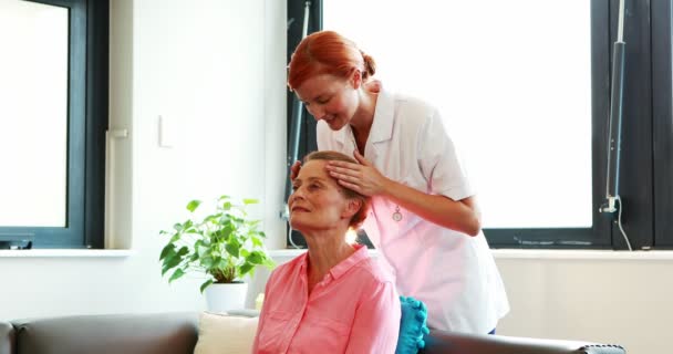 Sjuksköterskan gör ansiktsmassage till hennes äldre patient — Stockvideo