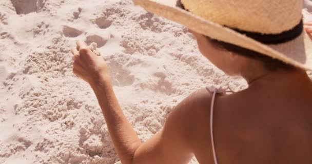 Frau sitzt auf einem Sand — Stockvideo