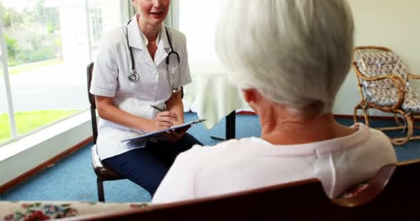 Krankenschwester im Gespräch mit einer geduldigen Seniorin — Stockvideo