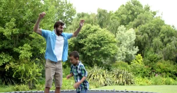 Father and son playing on the trampoline — Stock Video