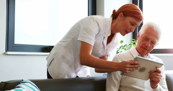 Sjuksköterska och senior patienten använder Tablet PC: n — Stockvideo