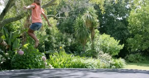 Sarışın kız trambolin üzerinde atlama — Stok video