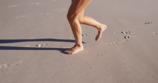Женщина бежит по пляжу — стоковое видео
