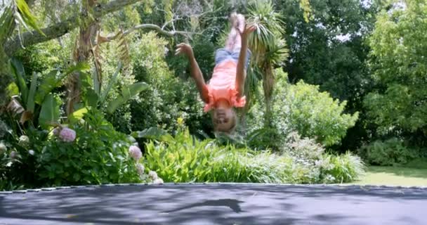 Blond tjej gör back flip på studsmatta — Stockvideo