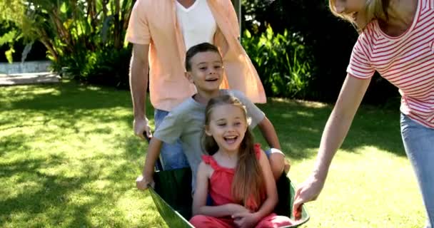 Family playing with the wheelbarrow in the garden — Stock Video