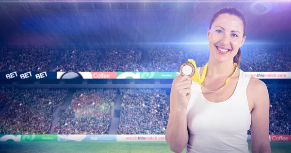 Kvinnliga idrottare poserar med guldmedalj — Stockfoto