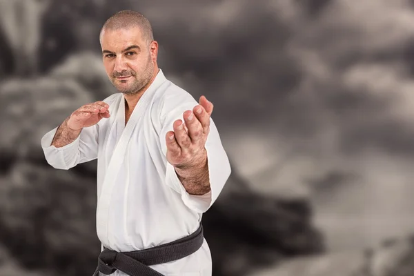 Composietbeeld van fighter uitvoeren van karate houding — Stockfoto