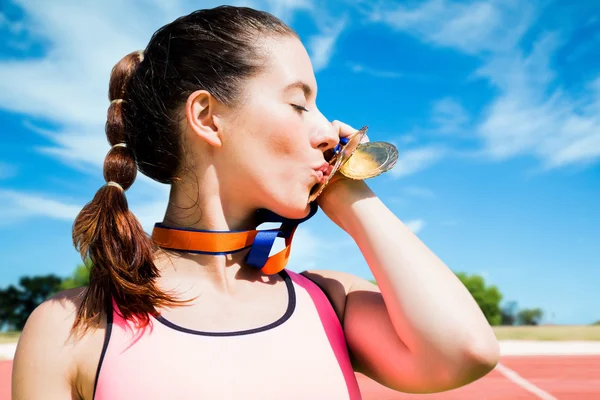 Sportswoman kissing her medals — Stock Photo, Image