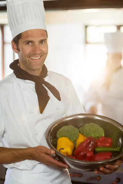 Sonriente chef mostrando tazón de verduras — Foto de Stock