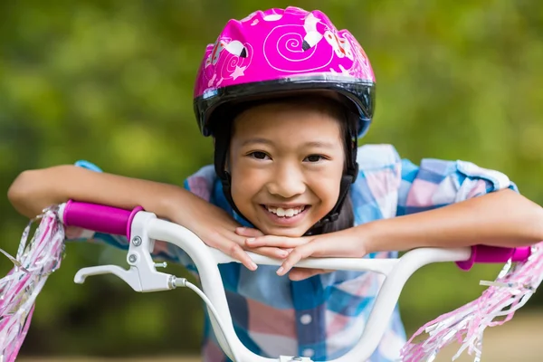 Chica sonriente apoyada en una bicicleta — Foto de Stock