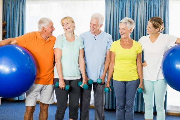 Seniors holding exercise ball and weights — Stock Photo, Image